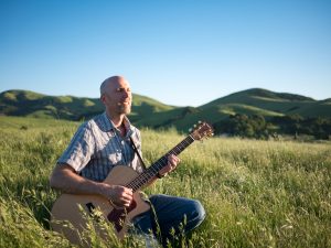 Playing Guitar Kneeling in the Grass