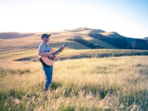 Standing Playing Guitar in the Amber Waves of Grain
